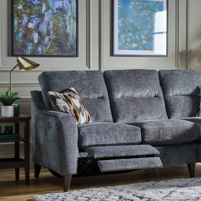 Gray sofa with reclining feature in a living room setting with framed artwork on the wall.