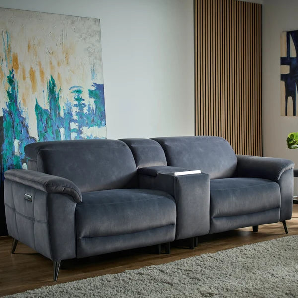 A modern gray fabric reclining loveseat sofa with a central cup holder and side table, shown in a styled living room setting.Interior Envy
