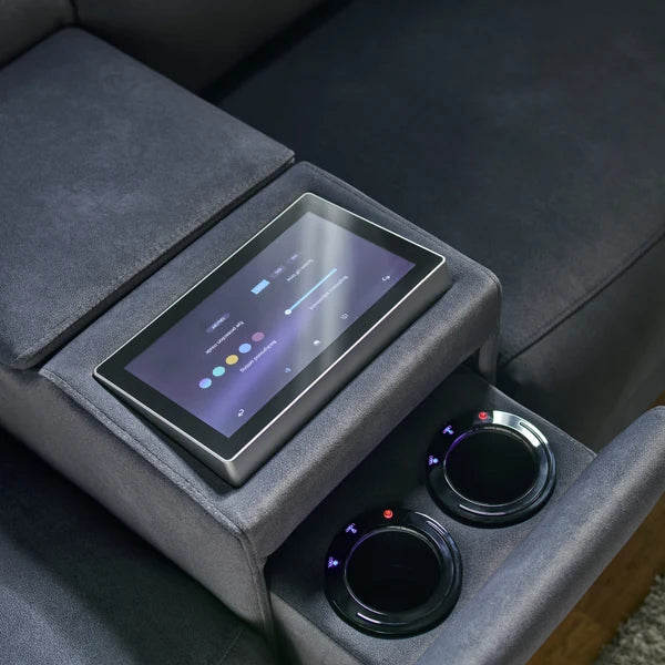 A close-up of a gray fabric car center console with a built-in touchscreen display, two circular cup holders, and illuminated control buttons. Interior Envy
